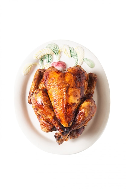 Concepto de comida Pollo orgánico entero asado, a la parrilla en plato de cerámica blanco aislado