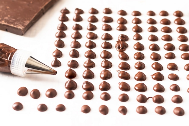 Concepto de la comida que hace las virutas de chocolate hechas en casa para la panadería en el fondo blanco