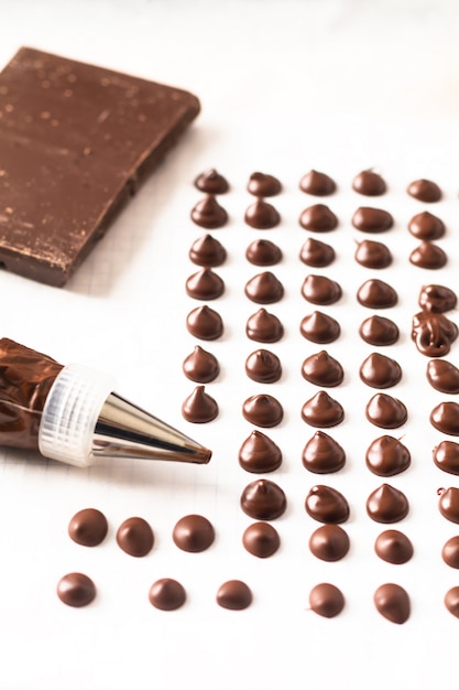 Concepto de la comida que hace las virutas de chocolate hechas en casa para la panadería en el fondo blanco