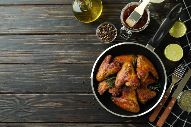 Concepto de comida sabrosa con alitas de pollo al horno en madera