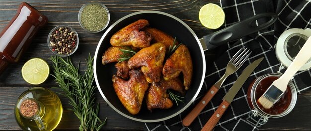 Concepto de comida sabrosa con alitas de pollo al horno sobre fondo de madera