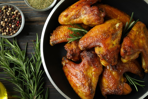 Concepto de comida sabrosa con alitas de pollo al horno sobre fondo de madera