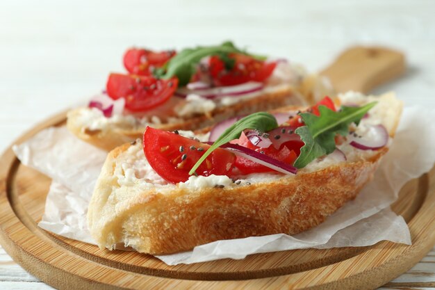 Concepto de comida sabrosa con bocadillos bruschetta en mesa de madera blanca