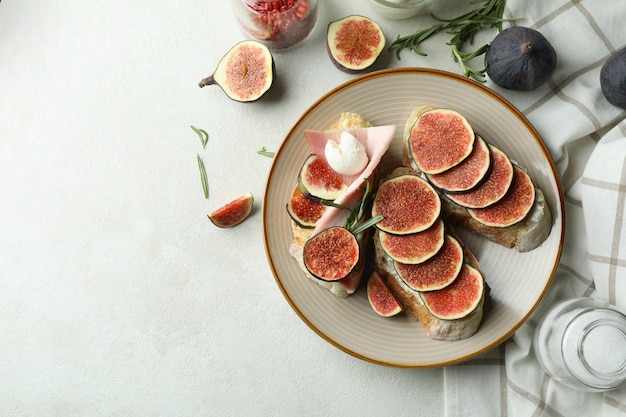 Concepto de comida sabrosa con bruschetta con higo en mesa con textura blanca