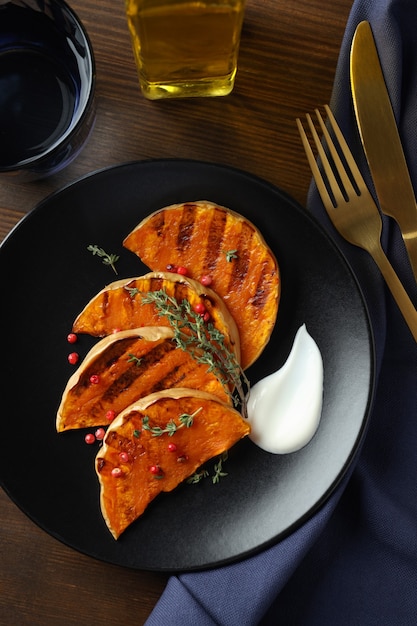 Concepto de comida sabrosa con calabaza al horno sobre fondo de madera.