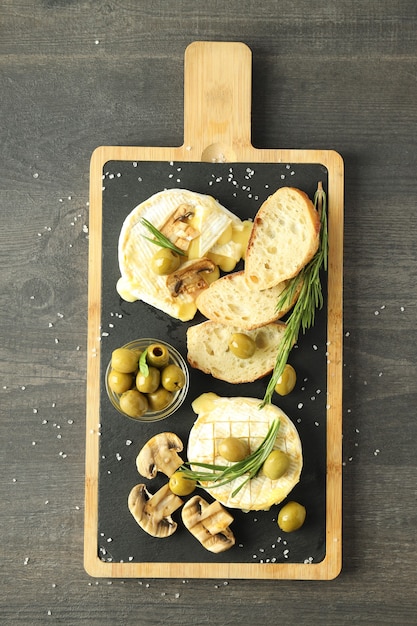 Concepto de comida sabrosa con camembert a la parrilla sobre fondo de madera oscura.