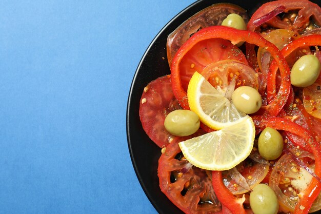 Foto concepto de comida sabrosa con carpaccio de tomate sobre fondo azul.