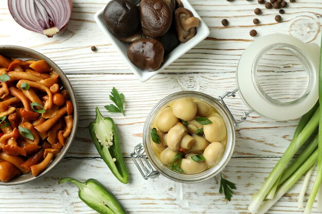 Concepto de comida sabrosa con champiñones marinados en mesa de madera