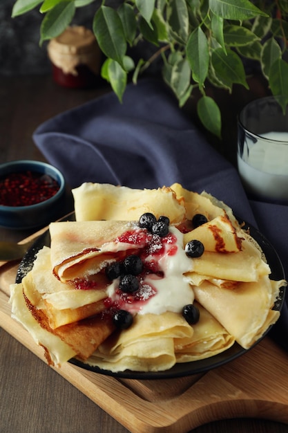 Concepto de comida sabrosa con crepes en mesa de madera