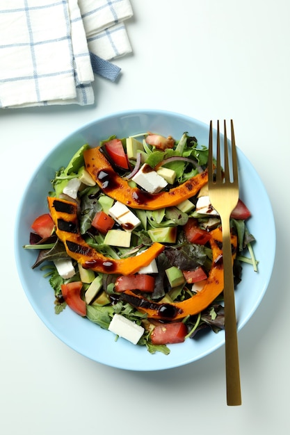 Concepto de comida sabrosa con ensalada de calabaza sobre fondo blanco.