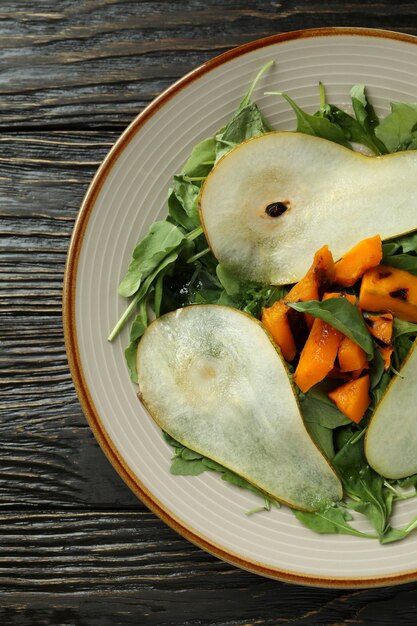 Concepto de comida sabrosa con ensalada de calabaza sobre fondo de madera