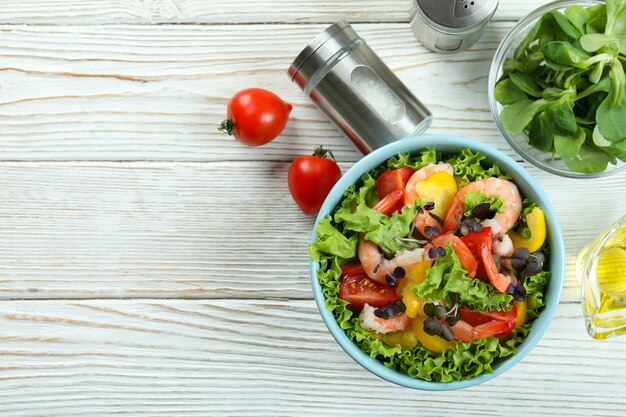 Concepto de comida sabrosa con ensalada de camarones en la mesa de madera blanca