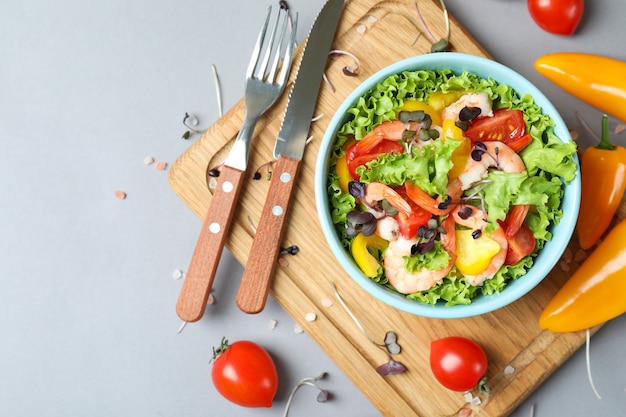 Concepto de comida sabrosa con ensalada de camarones sobre fondo gris