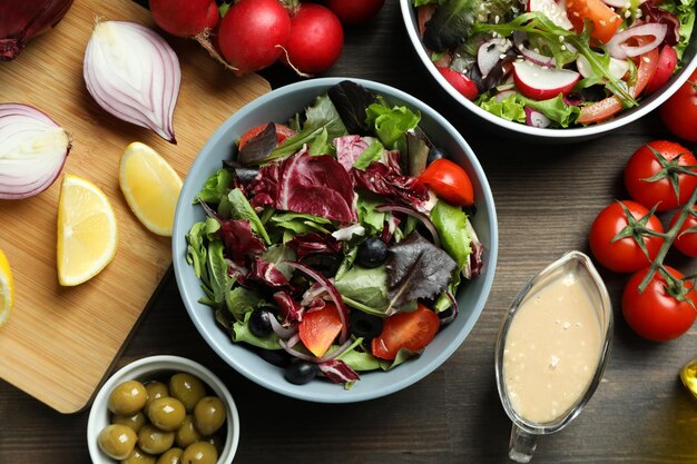 Concepto de comida sabrosa con ensalada de verduras con salsa tahini sobre fondo de madera