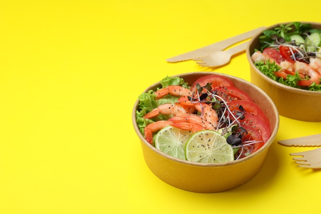 Concepto de comida sabrosa con ensaladas de camarones sobre fondo amarillo