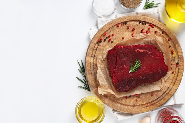 Concepto de comida sabrosa con filete de ternera cruda sobre fondo blanco.