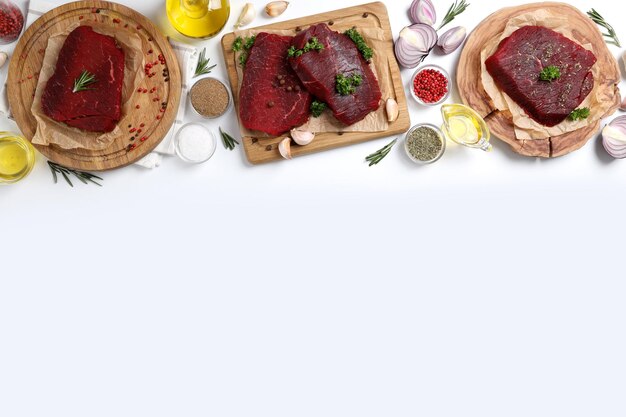 Concepto de comida sabrosa con filetes de carne cruda sobre fondo blanco.