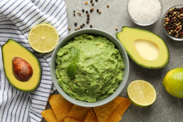 Concepto de comida sabrosa con guacamole e ingredientes sobre fondo gris