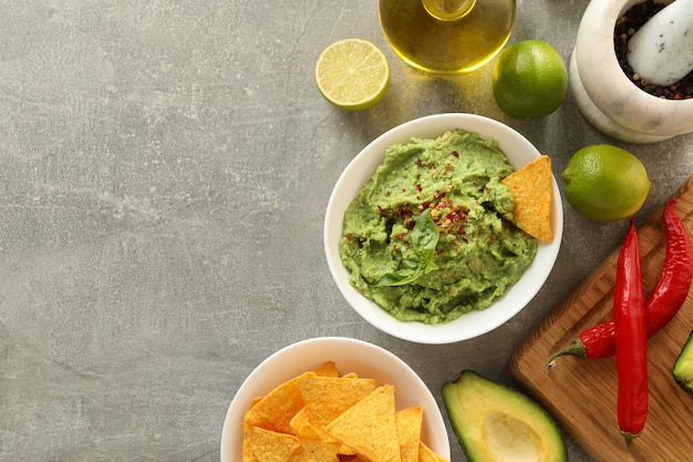 Concepto de comida sabrosa con guacamole e ingredientes sobre fondo gris