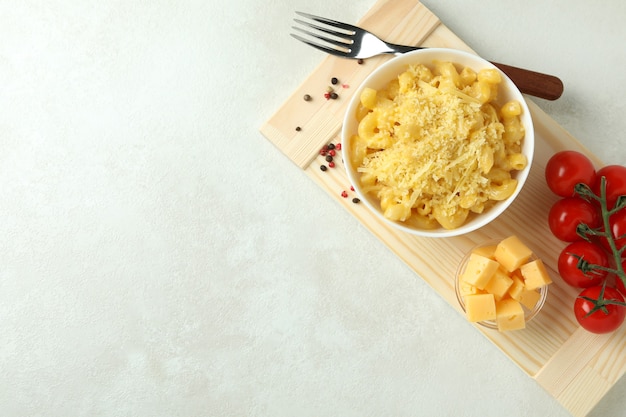 Concepto de comida sabrosa con macarrones con queso en la mesa con textura blanca