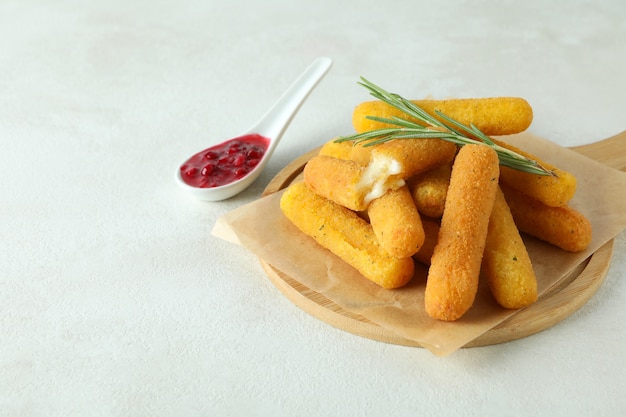 Concepto de comida sabrosa con palitos de queso sobre fondo de textura blanca