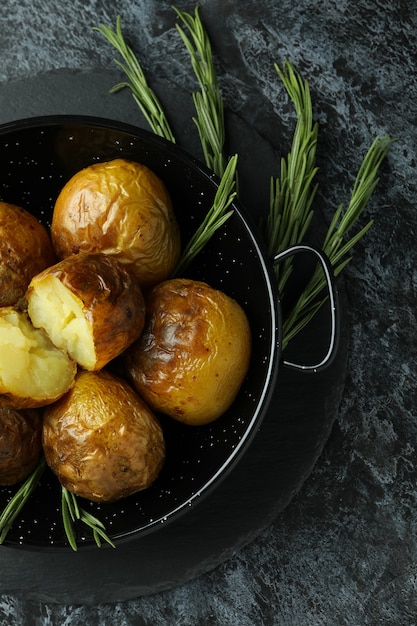 Concepto de comida sabrosa con patatas al horno en mesa ahumada negra.