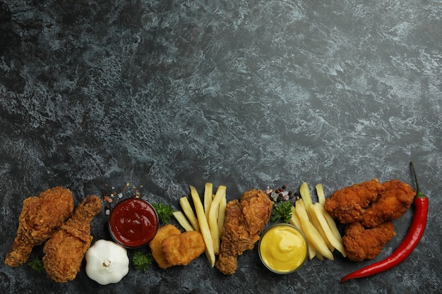Concepto de comida sabrosa con pollo frito sobre fondo negro ahumado