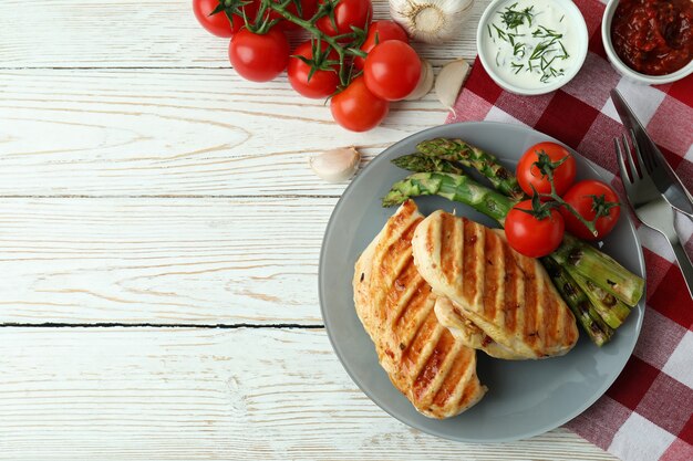 Concepto de comida sabrosa con pollo a la parrilla en la mesa de madera blanca