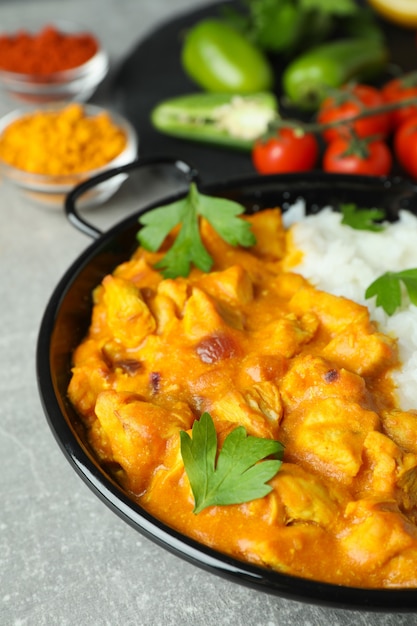 Concepto de comida sabrosa con pollo tikka sobre fondo de textura gris