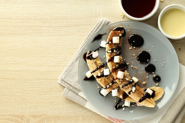 Concepto de comida sabrosa con postre de plátano en mesa de madera