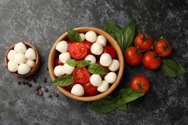 Concepto de comida sabrosa con queso mozzarella sobre fondo negro ahumado, vista superior