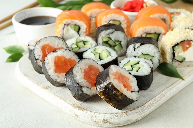 Concepto de comida sabrosa con rollos de sushi sobre fondo blanco texturizado