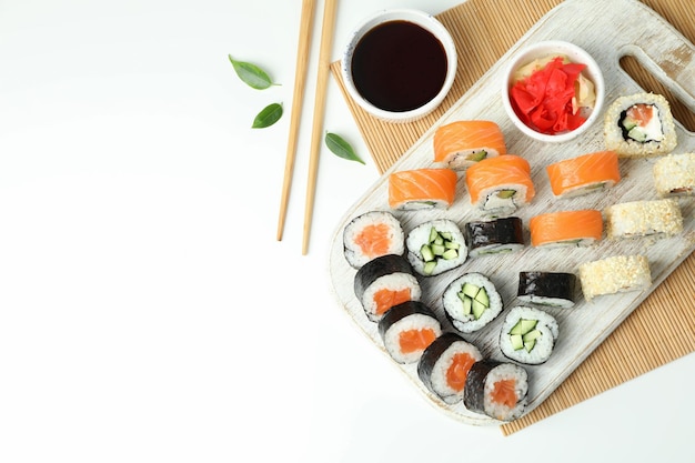 Concepto de comida sabrosa con rollos de sushi sobre fondo blanco.