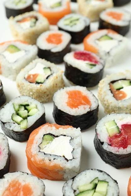 Concepto de comida sabrosa con rollos de sushi sobre fondo blanco.