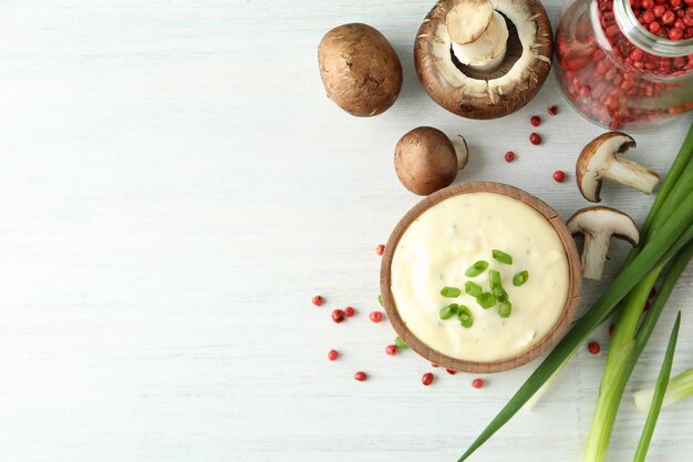 Concepto de comida sabrosa con salsa de champiñones sobre fondo blanco de madera