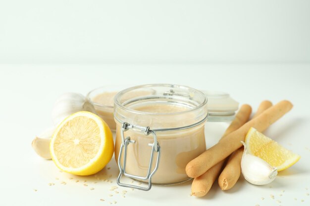 Concepto de comida sabrosa con salsa tahini en mesa blanca