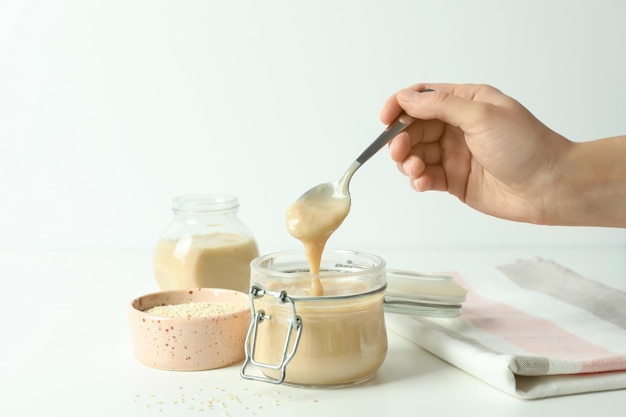 Concepto de comida sabrosa con salsa tahini en mesa blanca