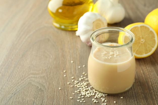 Concepto de comida sabrosa con salsa tahini sobre fondo de madera clara