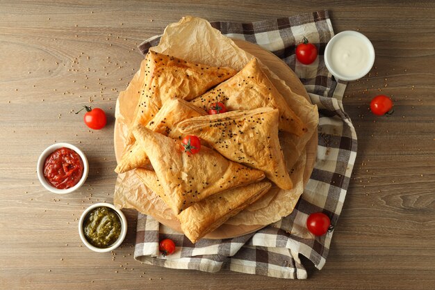 Concepto de comida sabrosa con samsa sobre fondo de madera