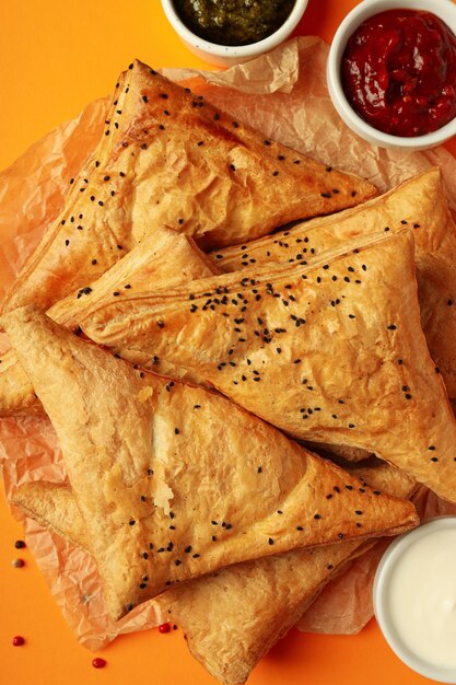 Concepto de comida sabrosa con samsa sobre fondo naranja