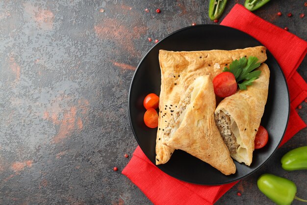 Concepto de comida sabrosa con samsa sobre fondo de textura oscura