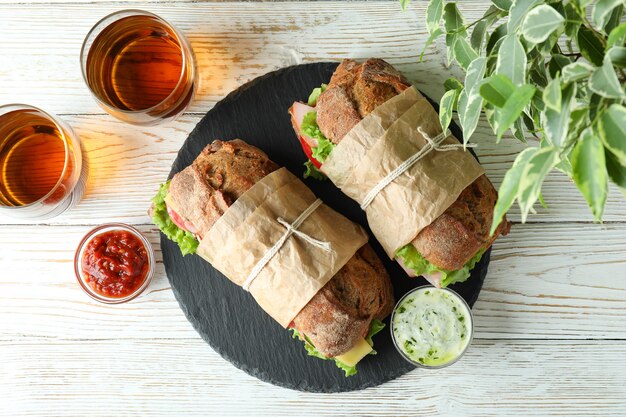 Concepto de comida sabrosa con sándwiches ciabatta en mesa de madera blanca