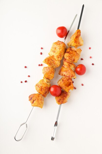 Foto concepto de comida sabrosa con shashlik de pollo sobre fondo blanco.