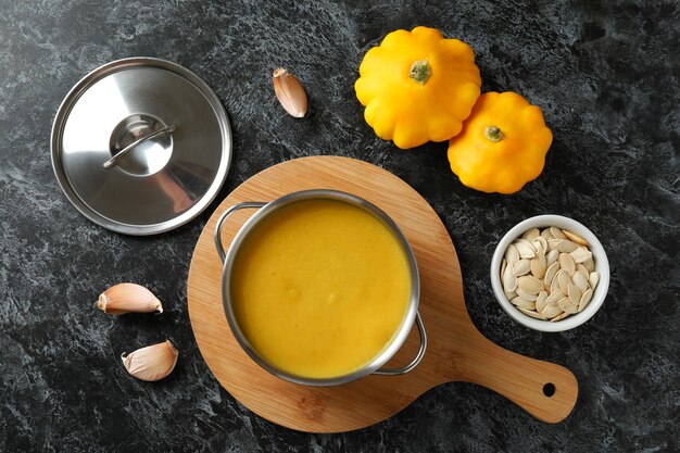 Concepto de comida sabrosa con sopa de calabaza en la mesa ahumada negra