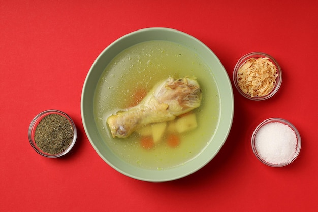 Concepto de comida sabrosa con sopa de pollo sobre fondo rojo.