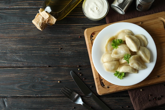 Concepto de comida sabrosa con vareniki o pierogi en mesa de madera