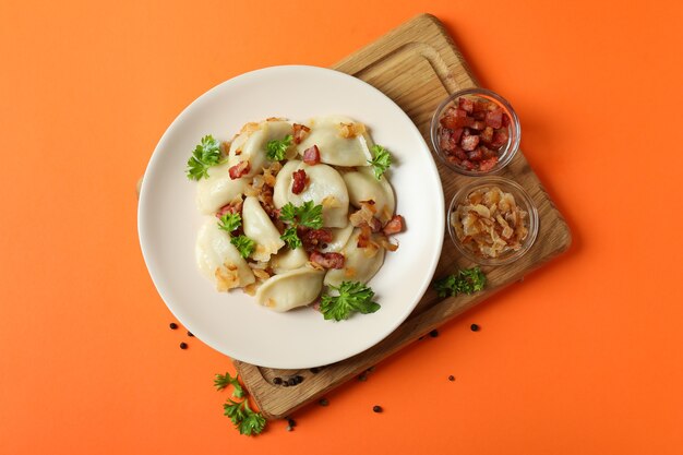 Concepto de comida sabrosa con vareniki o pierogi en naranja