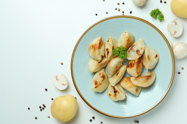 Concepto de comida sabrosa con vareniki o pierogi sobre superficie blanca