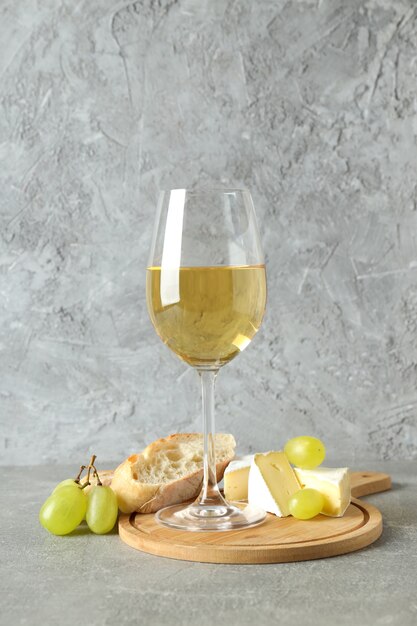 Concepto de comida sabrosa con vino blanco en mesa con textura gris