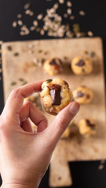 Concepto de comida saludable Masa cruda casera de Trail Mix orgánico Granos integrales Galletas energéticas en tabla de madera con espacio de copia